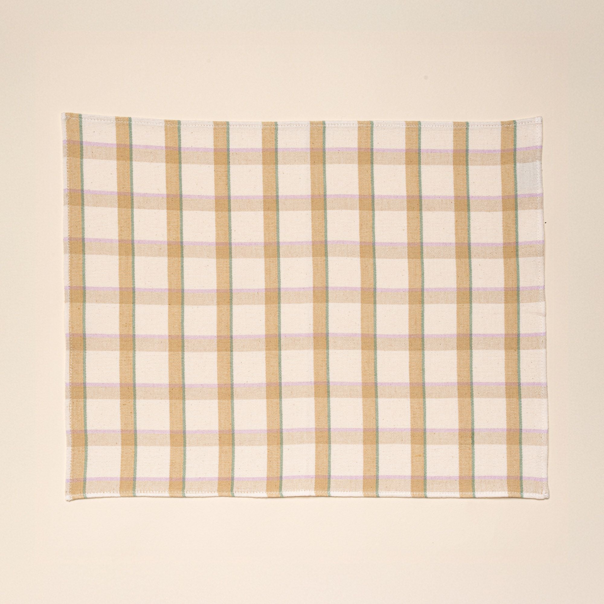 A rectangular plaid placemat with lines of pastel pink, teal, and peach.