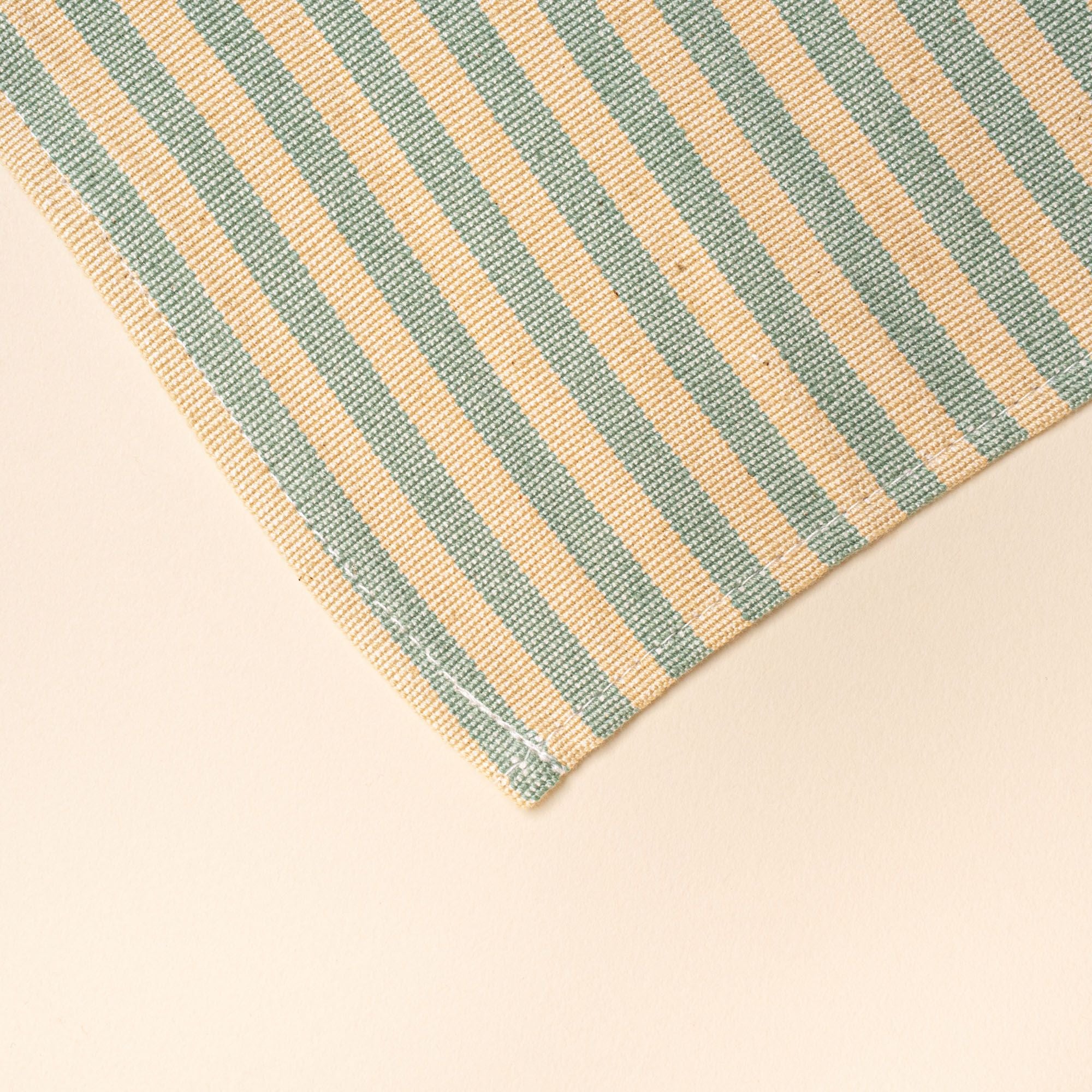 A corner of a peach and green striped napkin