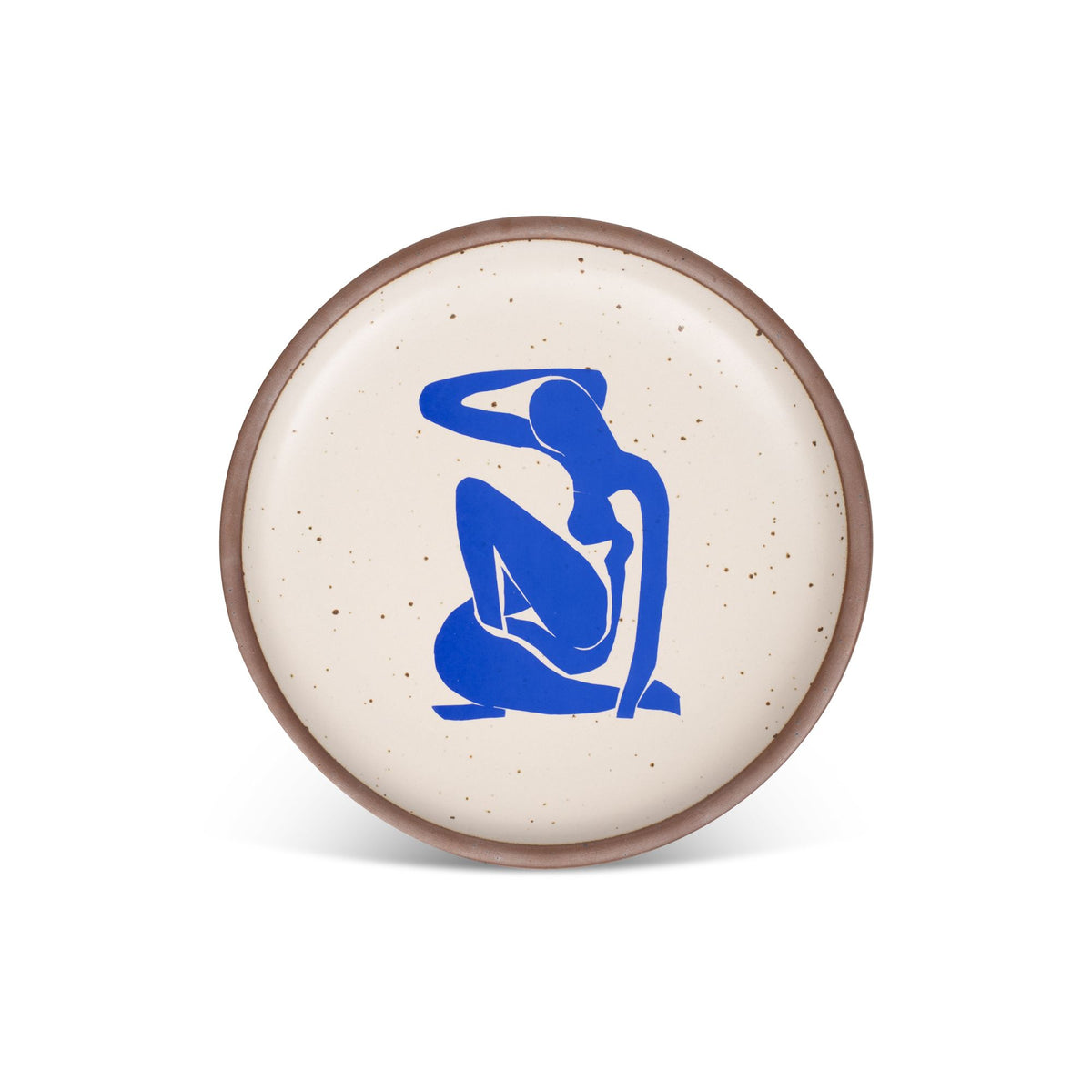 A plate featuring Nu Bleu I, by Henri Matisse, a bright blue, abstract, silhouetted female figure in a curled, seated position, with sharp cut-out edges, centered on an off-white ceramic plate with an unglazed rim.
