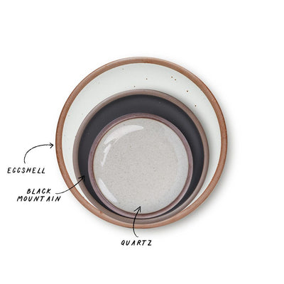 A stack of 3 plates in Dinner, Side, and Cake sizes in a cool white, graphite black, and reflective icy white colors.