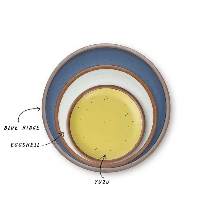 A stack of 3 plates in Dinner, Side, and Cake sizes in a cool medium blue, white, and zesty yellow colors.