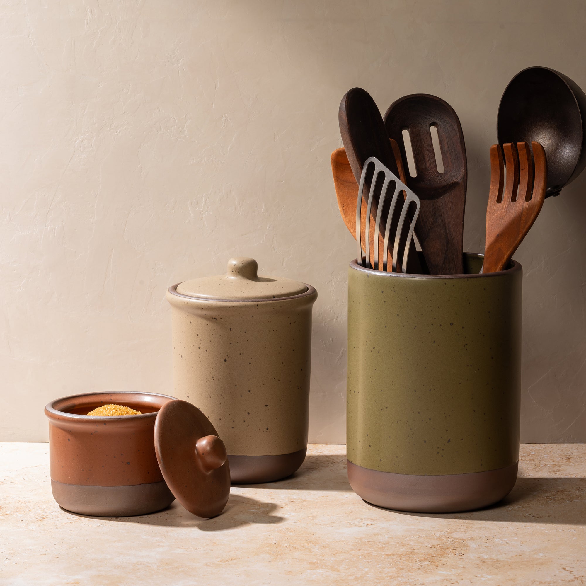 Ceramic Utensil Jar, Tall Jar, and Small Jar filled with spoons, utensils and sugar.