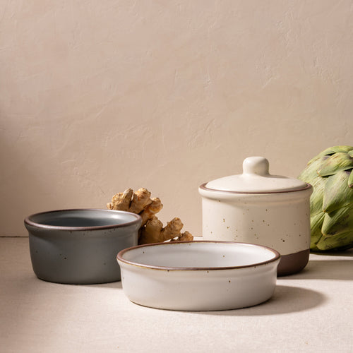 Ceramic short jar with lid, medium ramekin, and low wide ramekin with garlic and artichoke.