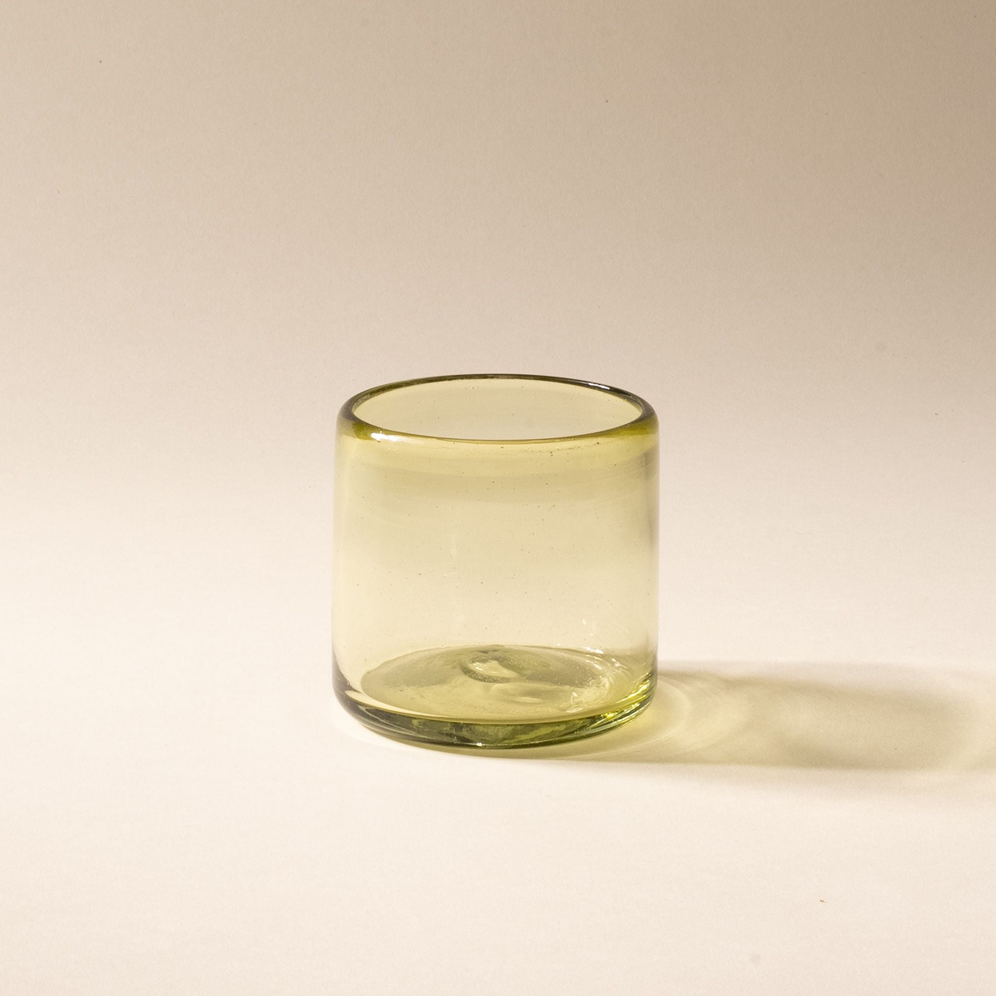 An olive green short transparent drinking glass