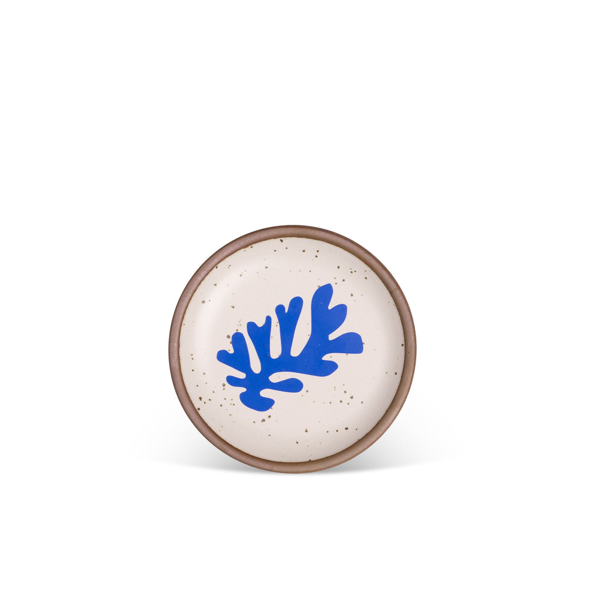 A ceramic dessert sized plates in a warm off-white color with unglazed rim, a frond-like cut-outs from Henri Matisse’s La Perruche et la sirène.