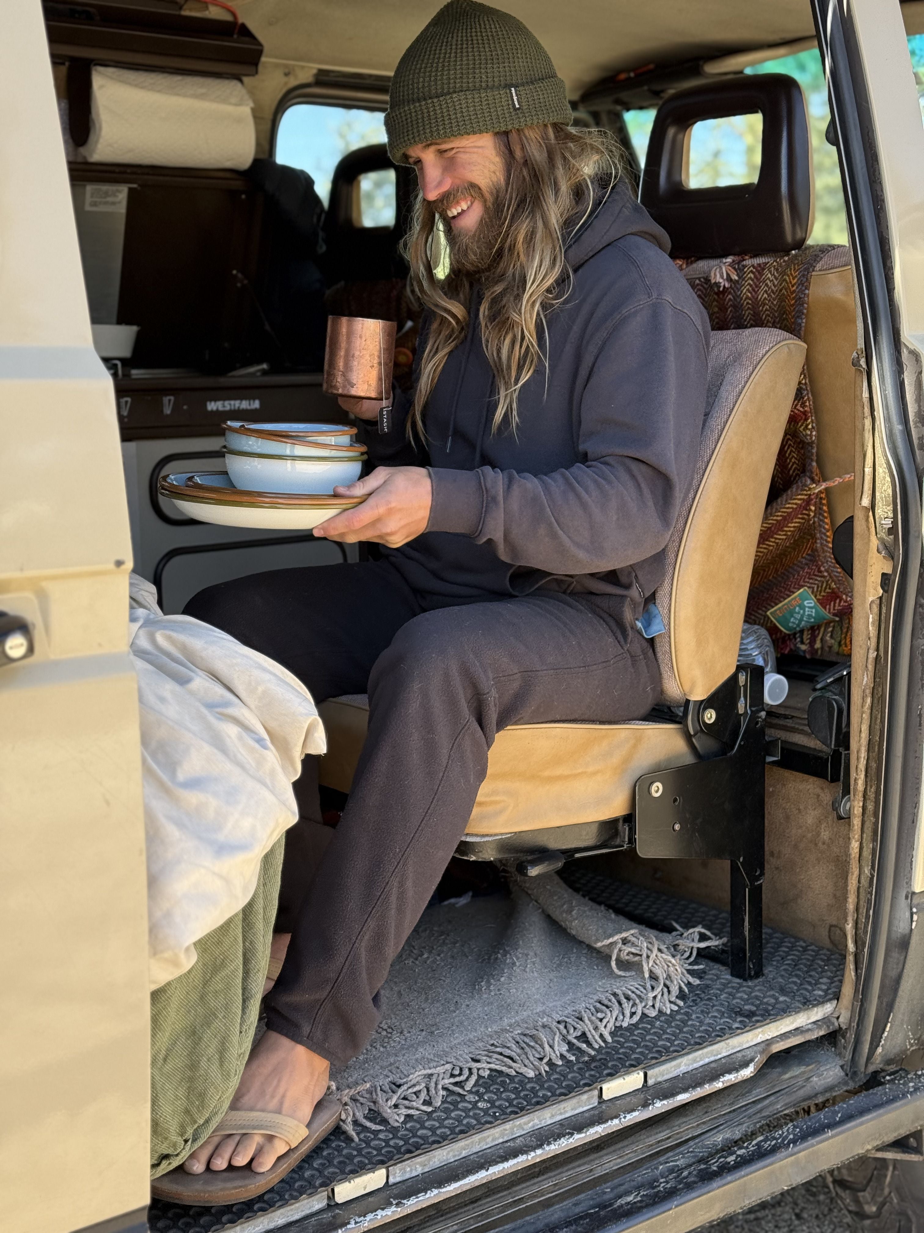 A man holds East Fork Enamelware in a VW Vanagon