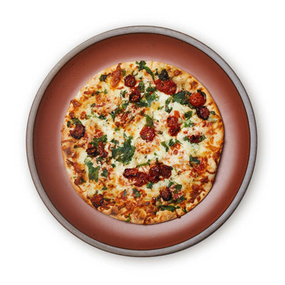 A round serving platter with a pizza