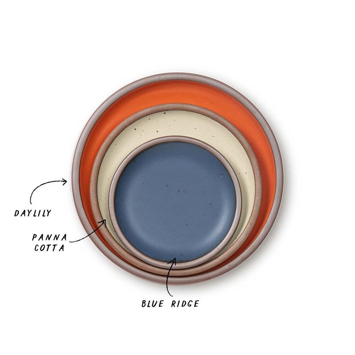 A stack of 3 plates in Dinner, Side, and Cake sizes in a bold orange, cream, and cool medium blue colors.