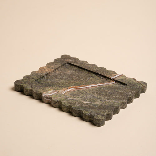 Rectangular green marble tray with scalloped edges and a bold diagonal vein of white and rust running across its surface.