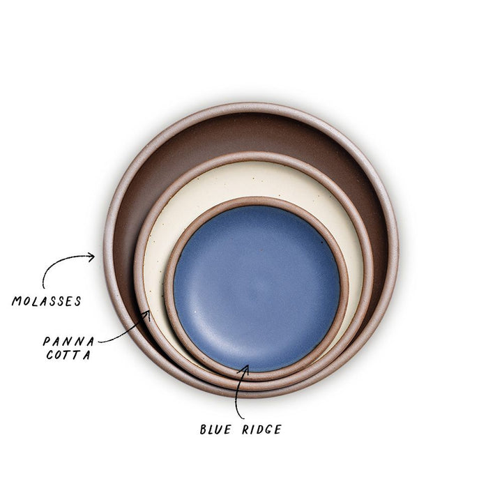 A stack of 3 plates in Dinner, Side, and Cake sizes in a dark brown, warm off-white, and navy colors.