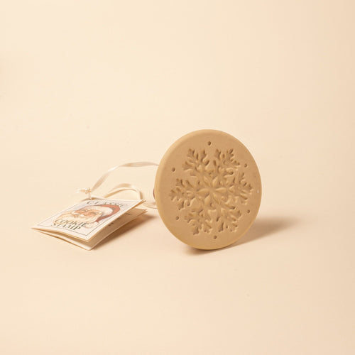 A round cookie stamp with a snowflake design, attached to a ribbon and tag labeled “Classic Cookie Stamp.”