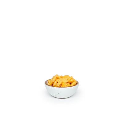 A tiny rounded ceramic bowl in a cool white color featuring iron speckles and an unglazed rim, filled with crackers