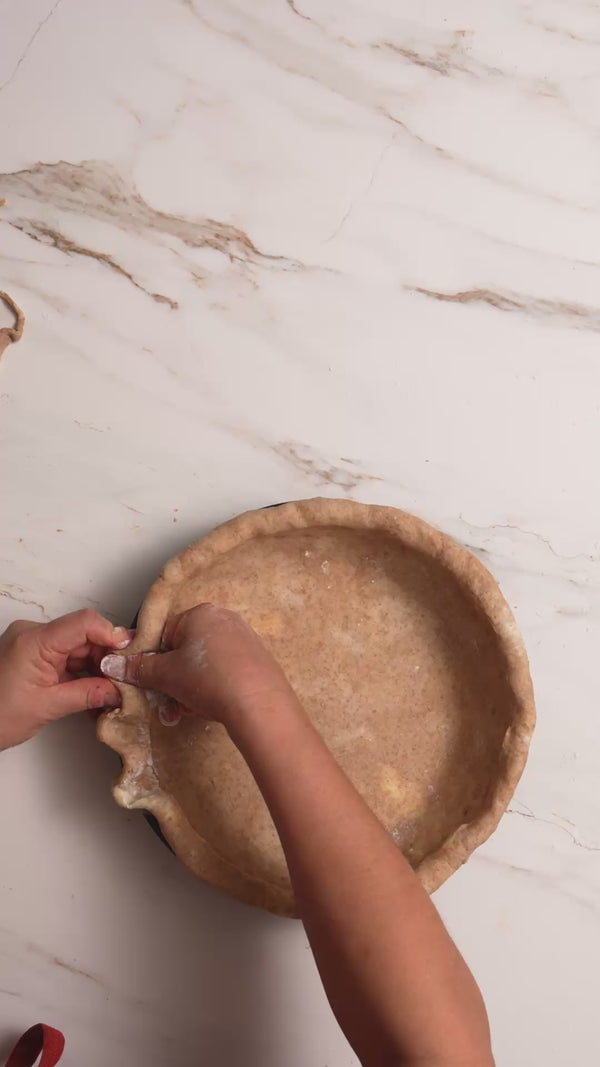 A video of someone making and baking a pie, cinnamon rolls, serving pie and dishes on a countertop.