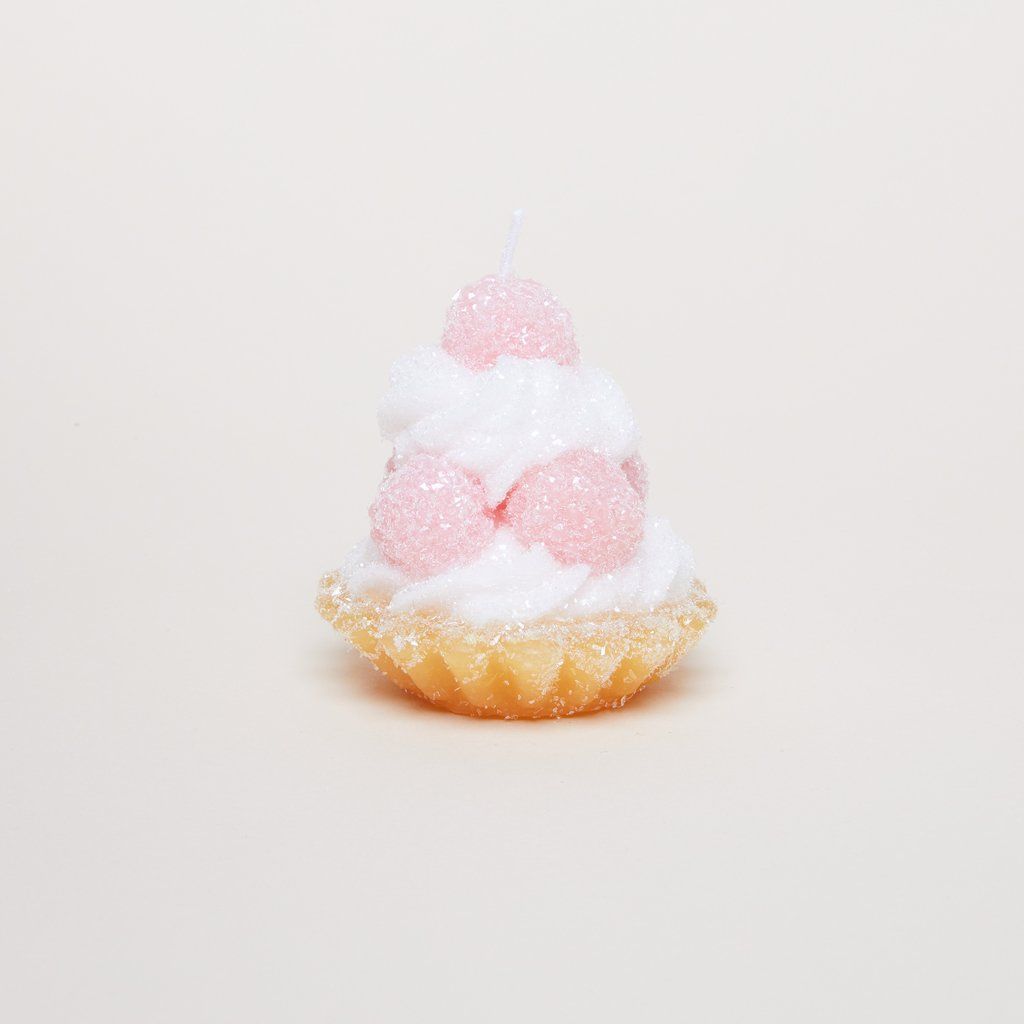 Pink, white and tan candle that has the size, shape and color of a tart with pale pink berries and icing.