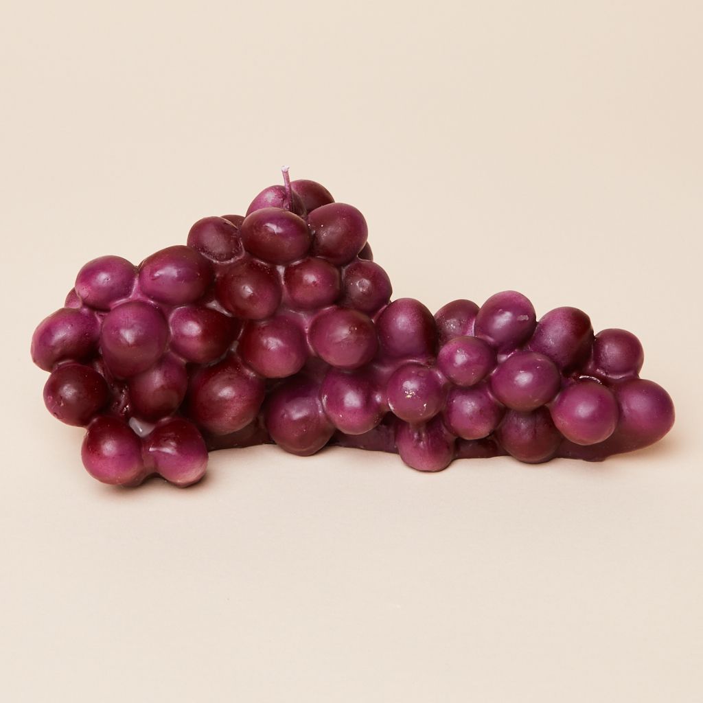 A purple candle made of similarly-sized oval shapes to resemble a bunch of grapes
