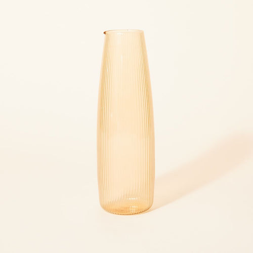 A tall, pale yellow pitcher with a spout at the rim