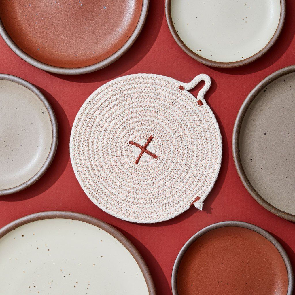 A trivet surrounded by East Fork plates
