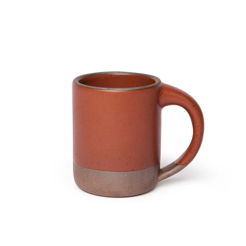A big sized ceramic mug with handle in a cool terracotte color featuring iron speckles and unglazed rim and bottom base.