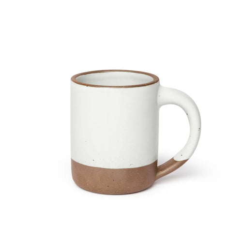 A big sized ceramic mug with handle in a cool white glaze featuring iron speckles and unglazed rim and bottom base.