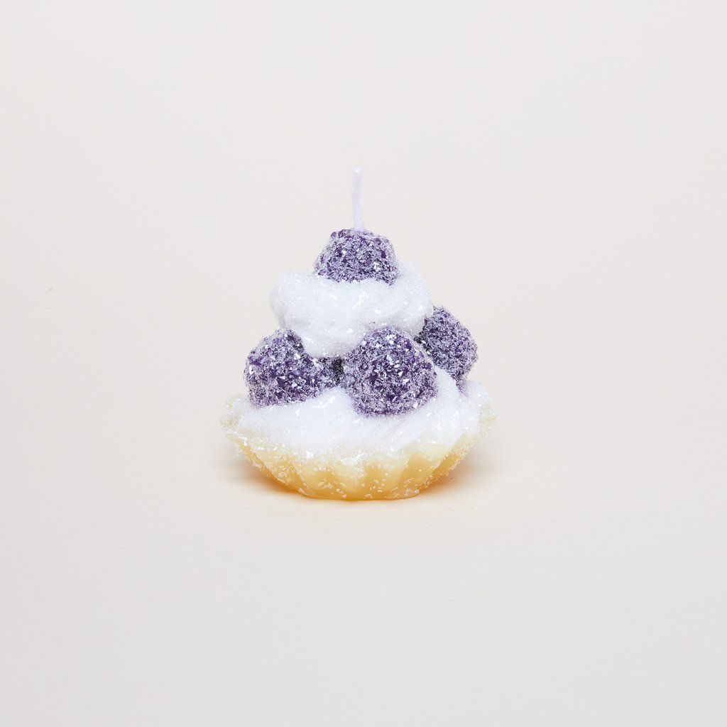 Round purple pieces of wax, wax that mimics icing and wax that looks like a pastry shell make up this tart-like candle.