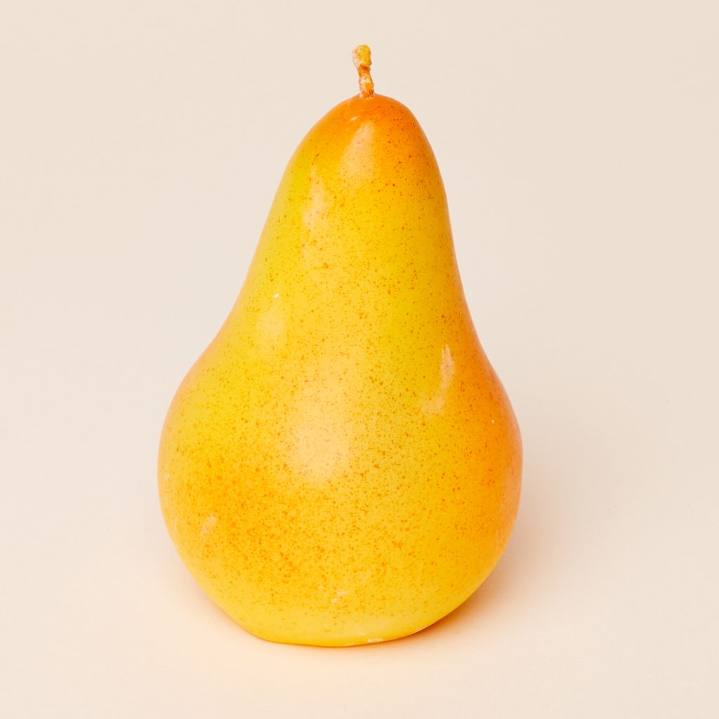 A bulbous bright yellow candle with brown spots to suggest a ripe pear